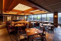a restaurant with tables and chairs and large windows at Karuizawa Prince Hotel West in Karuizawa