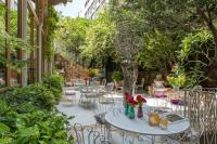 Un patio con mesas y sillas y árboles. en Arthaus Beirut, en Beirut