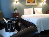 a hotel room with a bed and two glasses of wine at Hotel Oude Eycke in Maaseik