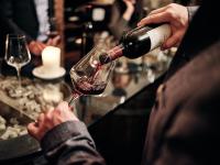 a person pouring wine into a wine glass at Hotel Pichlmayrgut in Schladming