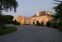 a large white house with a driveway at Hotel Hacienda Montenmedio in Vejer de la Frontera