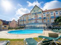 a hotel with a swimming pool in front of a building at Apartment Port Guillaume-6 by Interhome in Cabourg