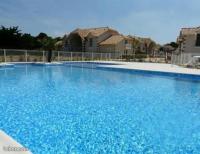 a large blue swimming pool in front of a house at PAREE D EAU 104 - Résidence avec piscine - Appartement rez de jardin 1 chambre in Notre-Dame-de-Monts