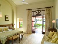 a bedroom with a bed and a couch at Taj Holiday Village Resort & Spa, Goa in Candolim