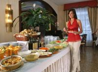 a woman standing in front of a buffet of food at Hotel Terme Salus in Abano Terme