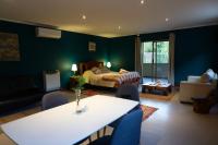 Una sala de estar con una cama, una mesa y sillas. en Lodge del Maipo, en San José de Maipo