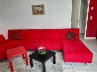 a red couch and a table in a living room at Foreword House in Albert