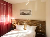 a bedroom with a bed with a wooden headboard at hotelo Heidelberg in Heidelberg