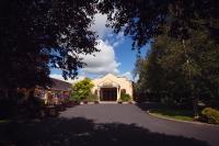 a driveway leading to a white building with a large doorway at Hamlet Court Hotel in Enfield