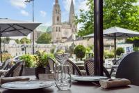 シャルトルにあるLe Boeuf Couronné - Hôtel & Restaurant Chartres- Logis Hotelsのワイングラスと皿付きのテーブル