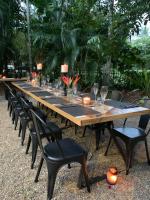 Una mesa larga de madera con sillas y copas de vino. en Golden Sands Beachfront Resort, en Yorkeys Knob