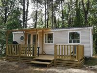 a tiny house with a porch and a deck at LE ILÔ - camping la dune blanche in Camiers