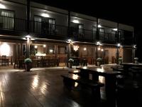 a restaurant with wooden tables and benches at night at I love phants Lodge in Ban Huai Thawai