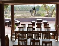 a restaurant with wooden tables and chairs and a large window at I love phants Lodge in Ban Huai Thawai