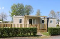 a small house with a wooden fence at Camping le Clos de Balleroy in Balleroy