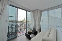 a living room with a white couch and a large window at Riva Arun Bangkok in Bangkok