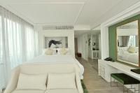 a bedroom with a large white bed and a mirror at Riva Arun Bangkok in Bangkok