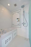 a white bathroom with a tub and a mirror at Riva Arun Bangkok in Bangkok