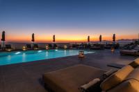 Una piscina con una puesta de sol al fondo en Rochari Hotel, en Mykonos ciudad