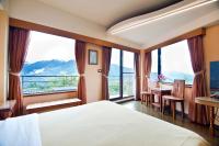 a hotel room with a bed and a desk and windows at Margaret Garden Villa in Ren&#39;ai