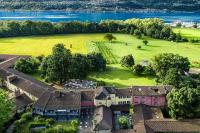 una vista aérea de una casa con un campo y agua en Castello del Sole Beach Resort&amp;SPA, en Ascona