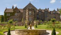 an old castle with a fountain in front of it at Florence Nightingale Suites at Lea Hurst in Highpeak Junction