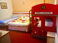 a bedroom with two beds and a red toy car at Hôtel Myosotis in Lourdes