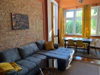a living room with a blue couch and a brick wall at Villa 25 in Gartz an der Oder