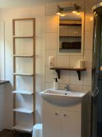 a bathroom with a sink and a mirror and shelves at Villa 25 in Gartz an der Oder