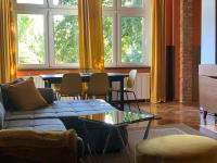 a living room with a couch and a table and windows at Villa 25 in Gartz an der Oder