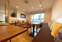 un ristorante con tavoli, sedie e un divano di Hotel Hanafuji Inn a Furano