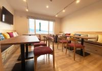 un ristorante con tavoli e sedie e una grande finestra di Hotel Hanafuji Inn a Furano