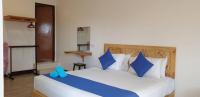 a bedroom with a large white bed with blue pillows at Paretto Seaview Hotel in Pantai Cenang