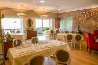 uma sala de jantar com mesas e cadeiras em um restaurante em Hotel Weiherhof am Golfpark em Wadern