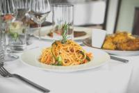 un plato de pasta en una mesa con copas de vino en Best Western Plus Pearl Addis, en Addis Ababa