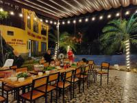 a long table with children sitting at it at night at Wings Ha Giang Loop Bungalow in Ha Giang