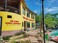 a building with a swimming pool next to a resort at Wings Ha Giang Loop Bungalow in Ha Giang