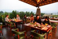 a group of people sitting at tables in a restaurant at Fazlani Natures Nest - The Wellness Retreat in Lonavala