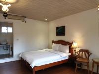 a bedroom with a bed and a table with a chair at Monet Garden Coffee Farm in Chinan