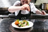 a chef in a kitchen preparing a plate of food at The Address Connolly in Dublin