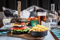 a hamburger and french fries on a table with beer at The Address Connolly in Dublin