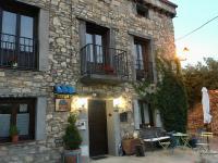 a stone house with a table and chairs in front of it at Ana de las Tejas Azules in Medinaceli
