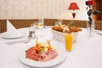 a table with a plate of food and a basket of bread at Calimbra Wellness Hotel Superior in Miskolctapolca