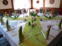 Una mesa larga con un mantel blanco y servilletas verdes. en Ratskeller Thum, en Thum