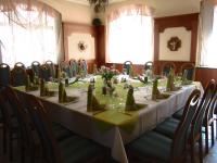 una mesa larga con servilletas verdes y flores. en Ratskeller Thum, en Thum