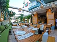 un restaurant avec une grande table et des chaises en bois dans l'établissement Yeshill Boutique Hotel, à Marmaris