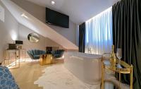a living room with a large window and a tub at Lumiere Luxury Rooms in Split