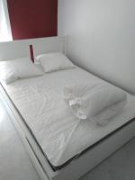ein weißes Bett mit weißer Bettwäsche und Kissen in der Unterkunft Appartement hypercentre au 2ème, ZOO - 24h du Mans in La Flèche
