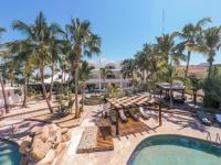 Una vista aérea de un resort con piscina y palmeras. en Hotel &amp; Suites El Moro, en La Paz