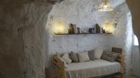 a living room with a couch in a stone wall at Casa Cueva “La Estrella” in Granada
